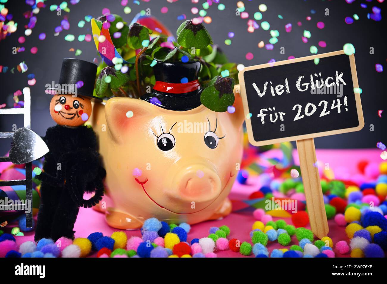 FOTOMONTAGE, Glücksschwein mit Kleeblättern, Schornsteinfegerfigur und Schild mit Aufschrift Viel Glück für 2024! mit Konfetti Stock Photo