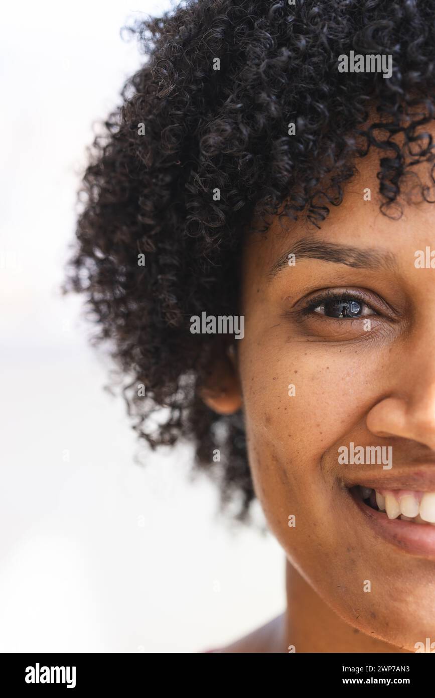 Close-up of a smiling young biracial woman with curly hair Stock Photo ...