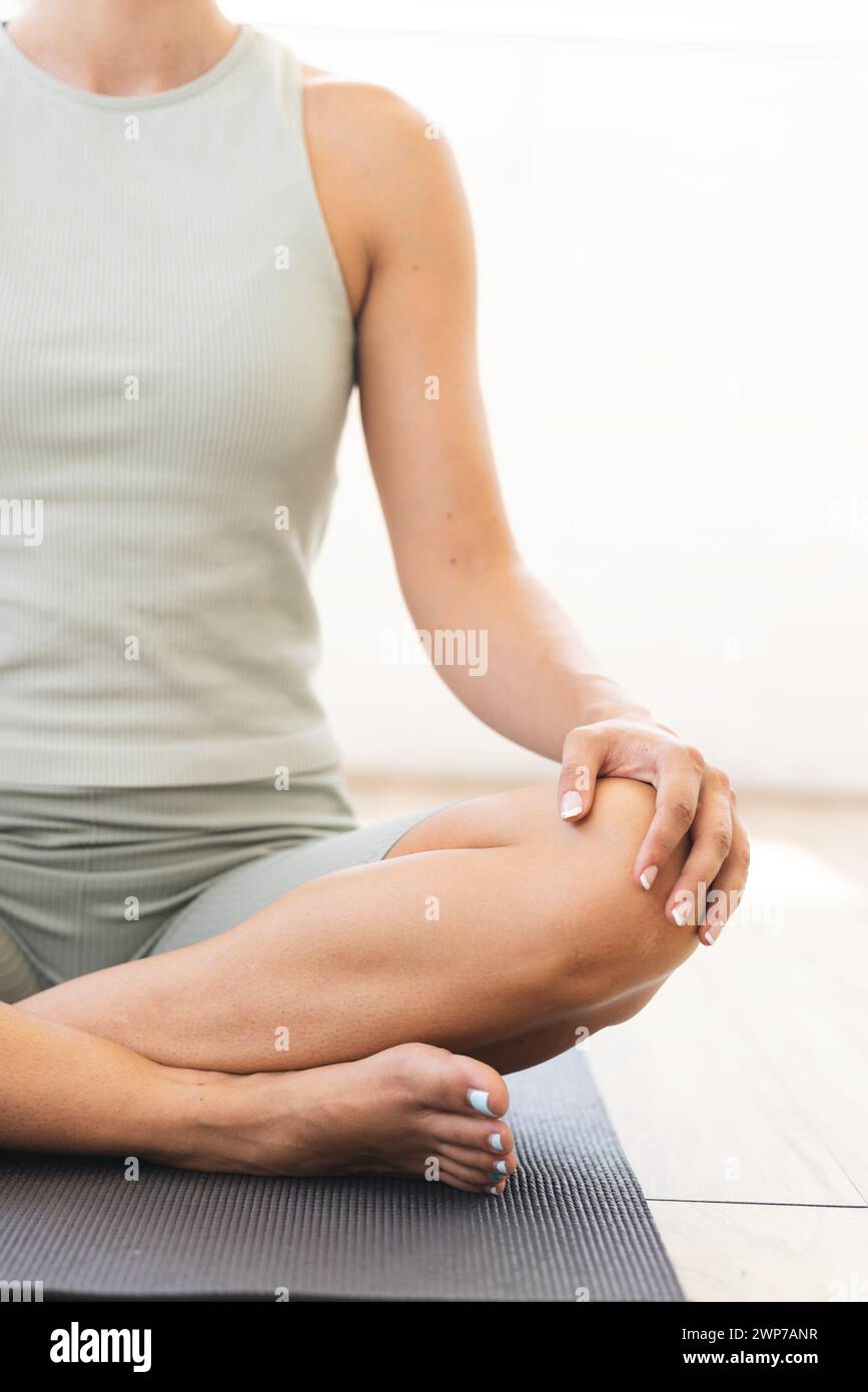 Young Caucasian woman practices yoga at home, sitting on a mat Stock ...