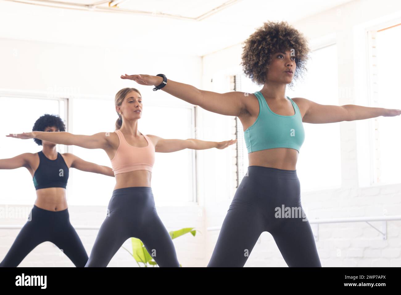 Young Caucasian woman leads a yoga class at a bright studio Stock Photo