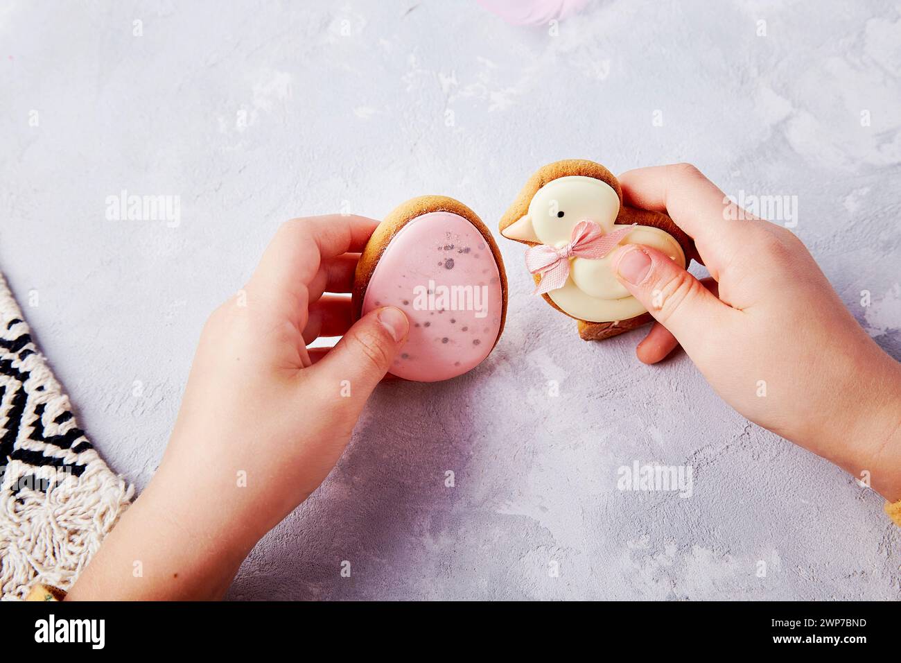 Easter cookies in the hands of a child, capturing tasty traditions. Stock Photo