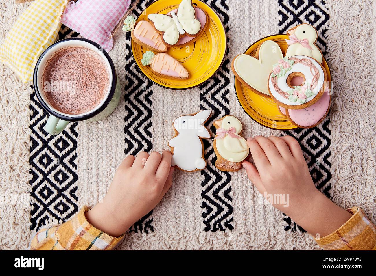 Holding Easter cookies, childs hands create a background of happy Easter traditions Stock Photo
