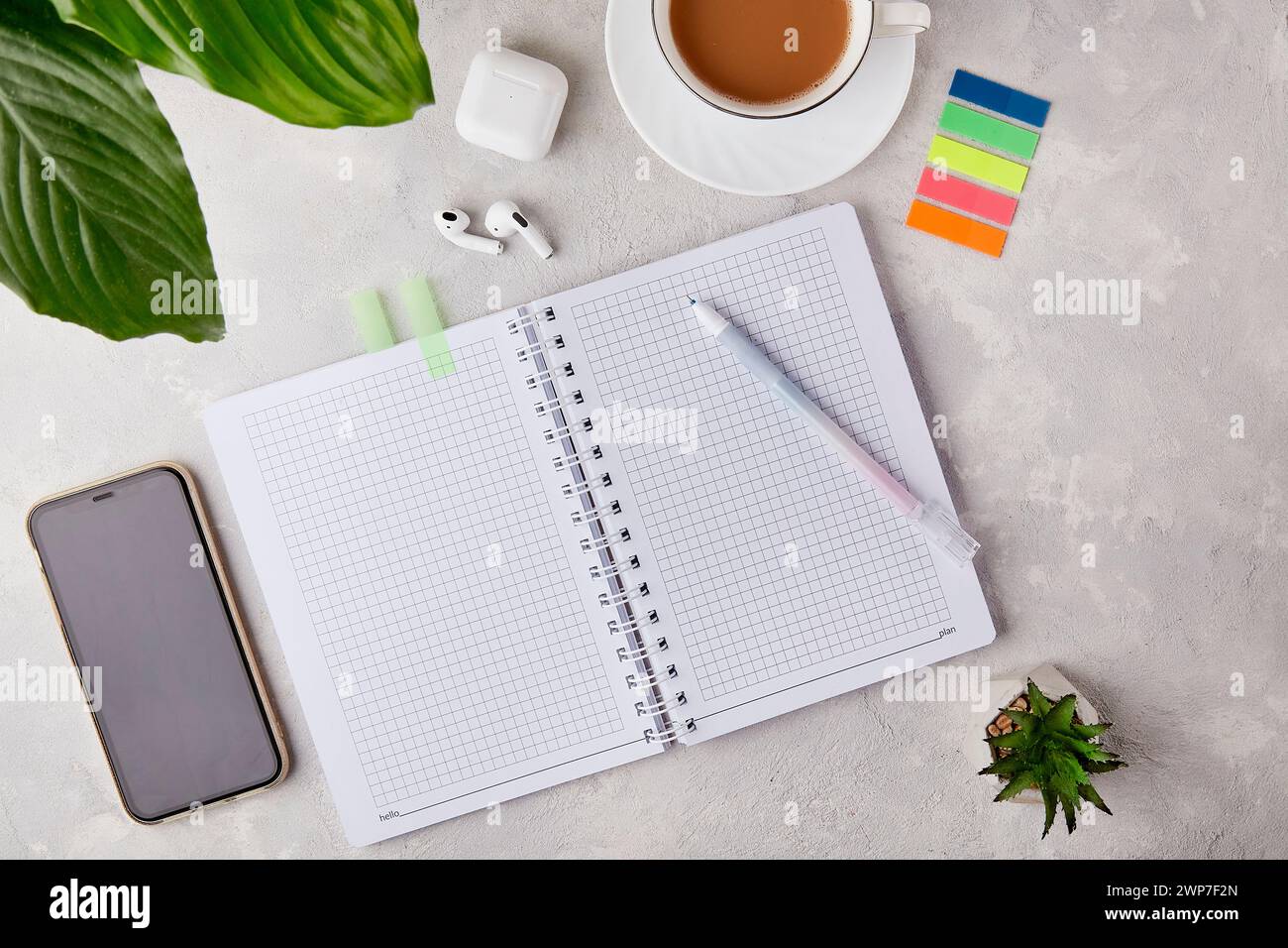 Creative Workspace Elegance: Open Notebook and Pen Flat Lay, audio earphones, phone mock up and coffee cup. Stock Photo