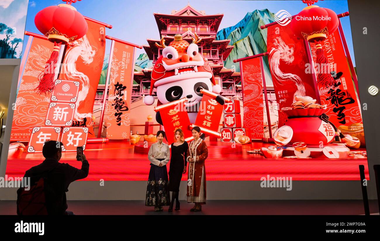 Besucherinnen vor Grossdisplay, Messestand China Mobile, MWC Mobile World Congress 2024, Barcelona, Spanien Stock Photo