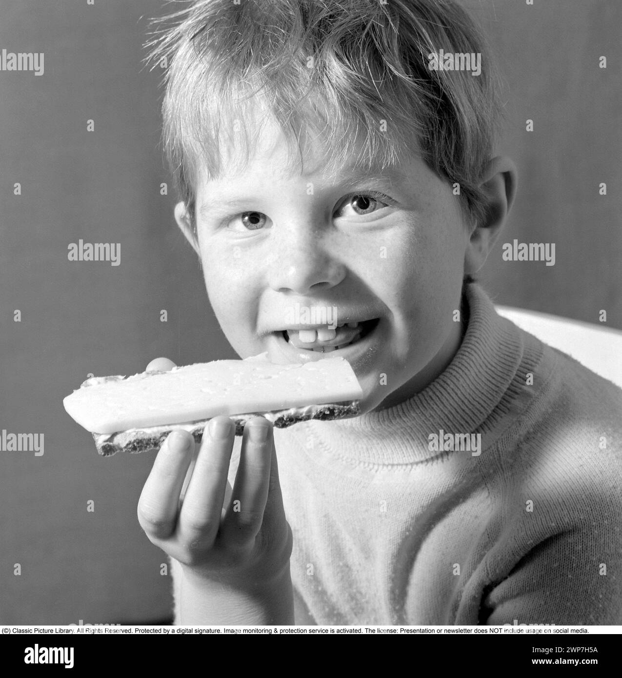 In the 1960s. A boy is eating a cheese sandwich. 1969. Conard ref 5818 Stock Photo