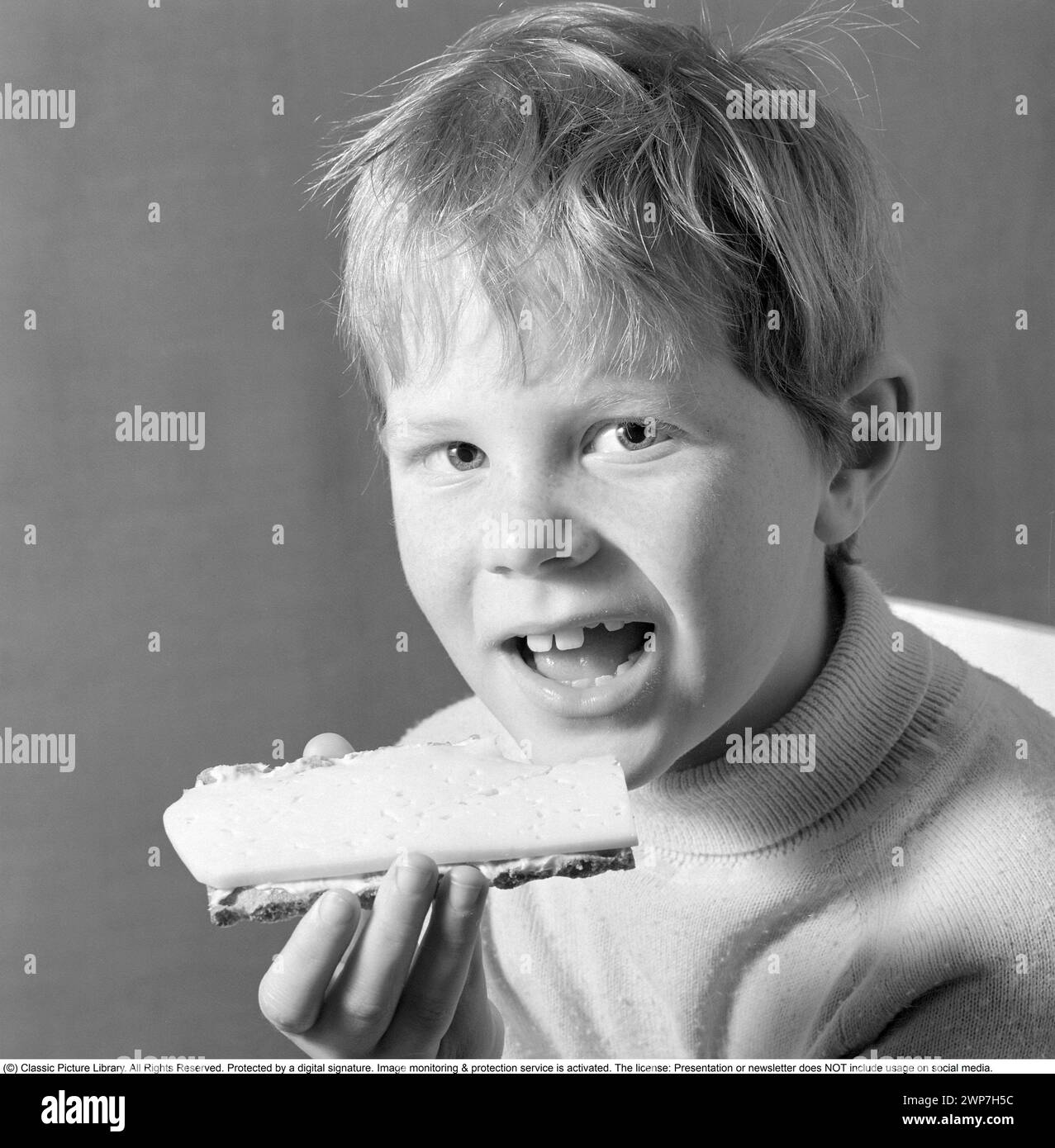 In the 1960s. A boy is eating a cheese sandwich. 1969. Conard ref 5818 Stock Photo
