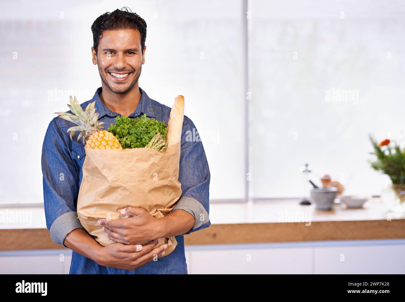 Groceries, bag and portrait of man with healthy food in kitchen for nutrition, diet or cooking in home. Happy, customer and vegan person with a smile Stock Photo