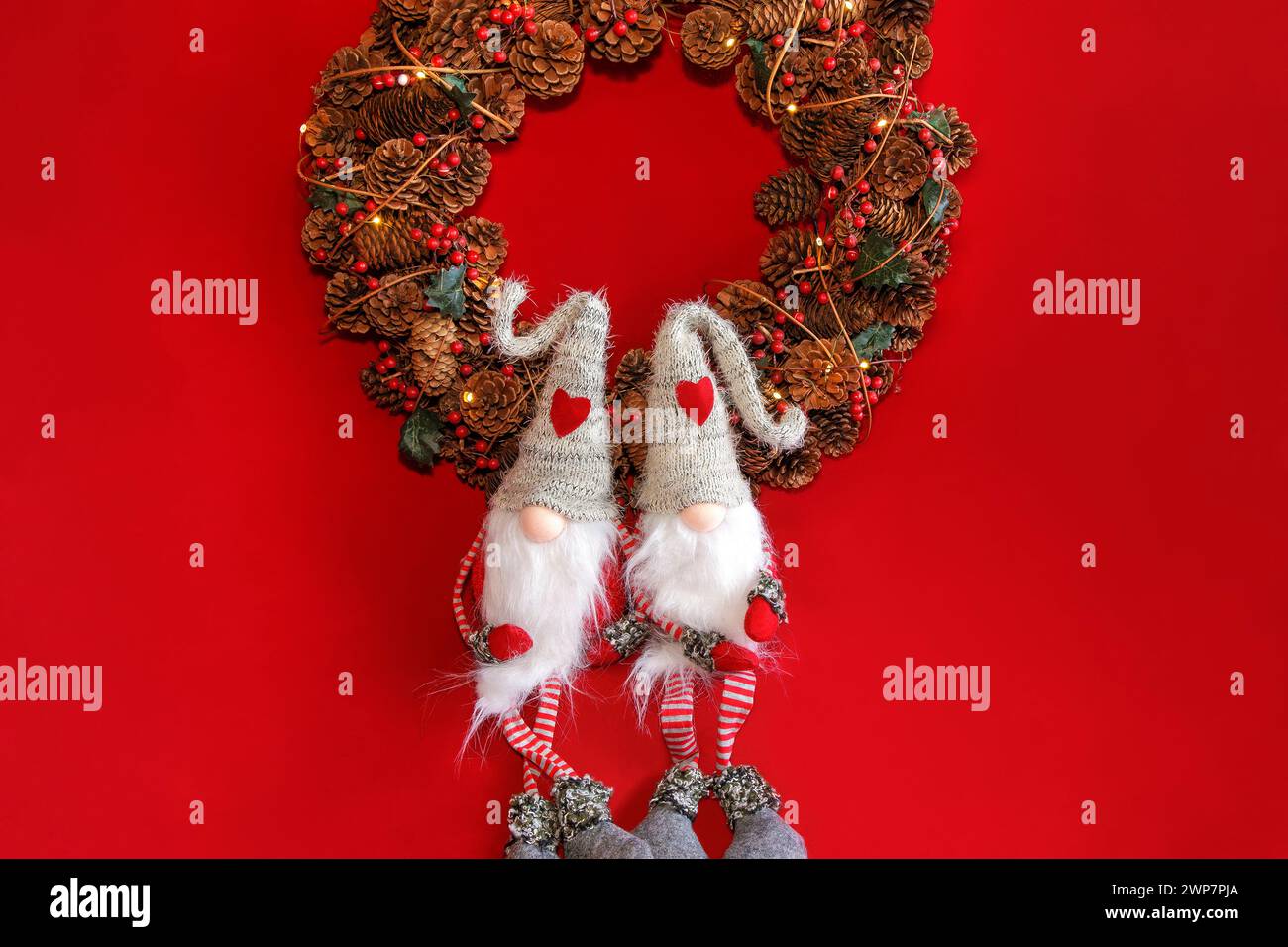 Two gnomes sitting under a Christmas wreath Stock Photo
