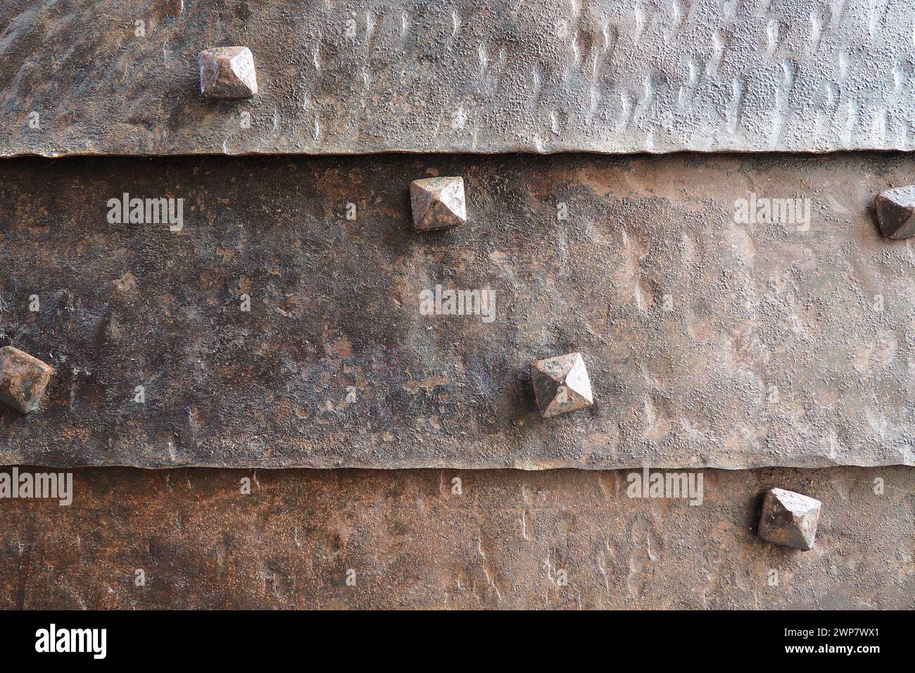 Background of metal surface from sheets with rivets, close-up. Texture of the iron gate. A metal relief backing for branding. Herceg Novi, Montenegro Stock Photo