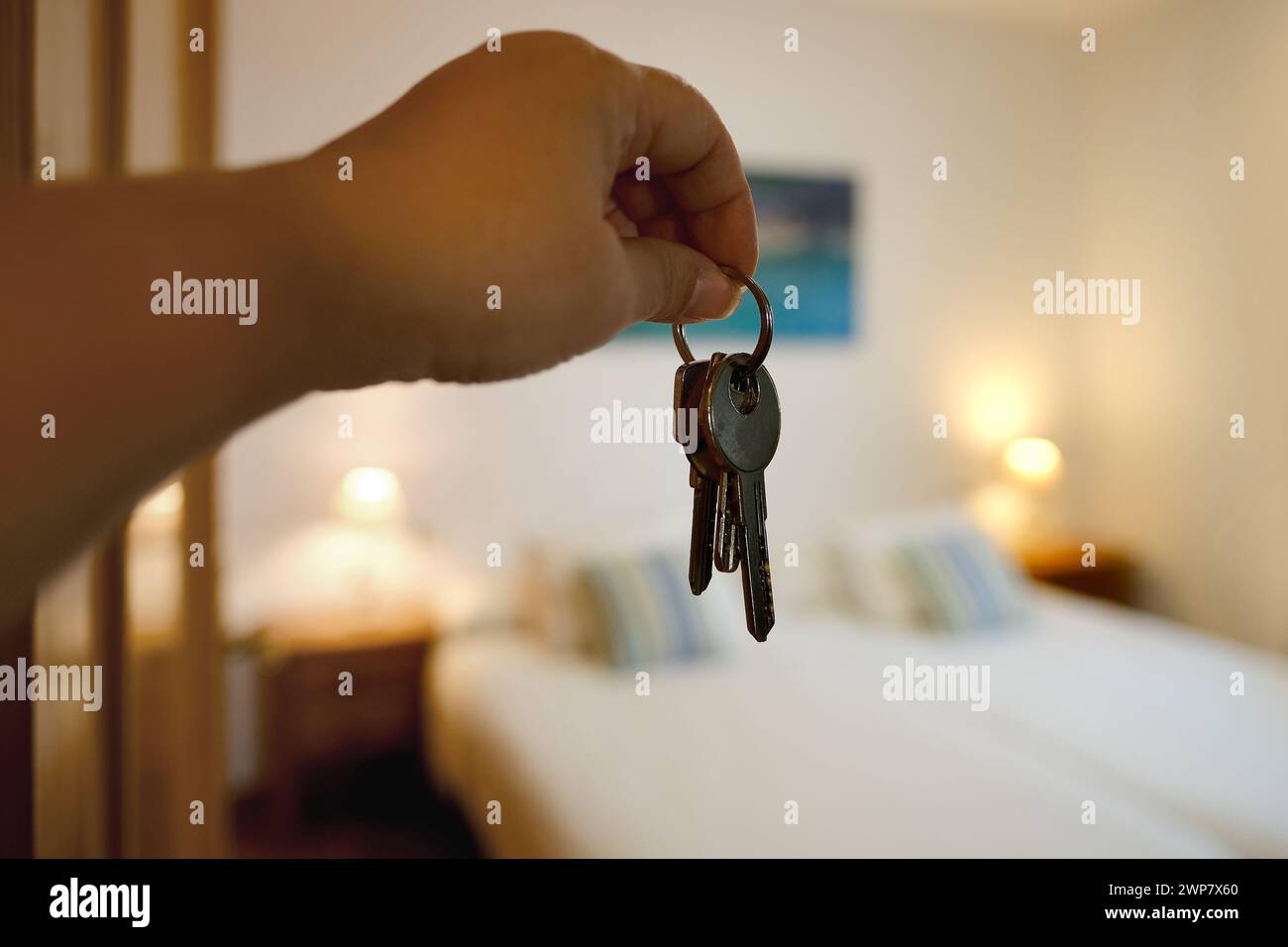 hand with bunch keys against modern bright room, Room for Rent, Comfortable Family Bed for Restful, Room Rental and Housing Solutions Stock Photo