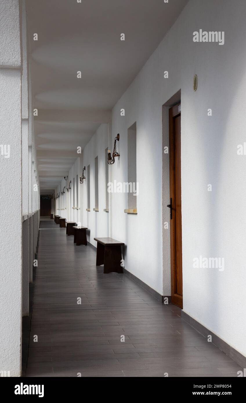 A long, straight corridor with white walls Stock Photo