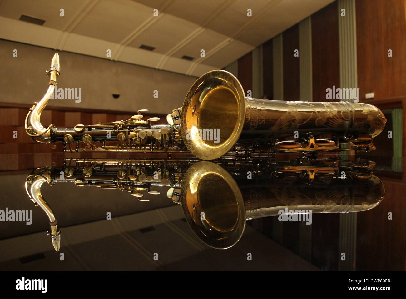 A Reflection of a saxophone in a concert hall's glass Stock Photo