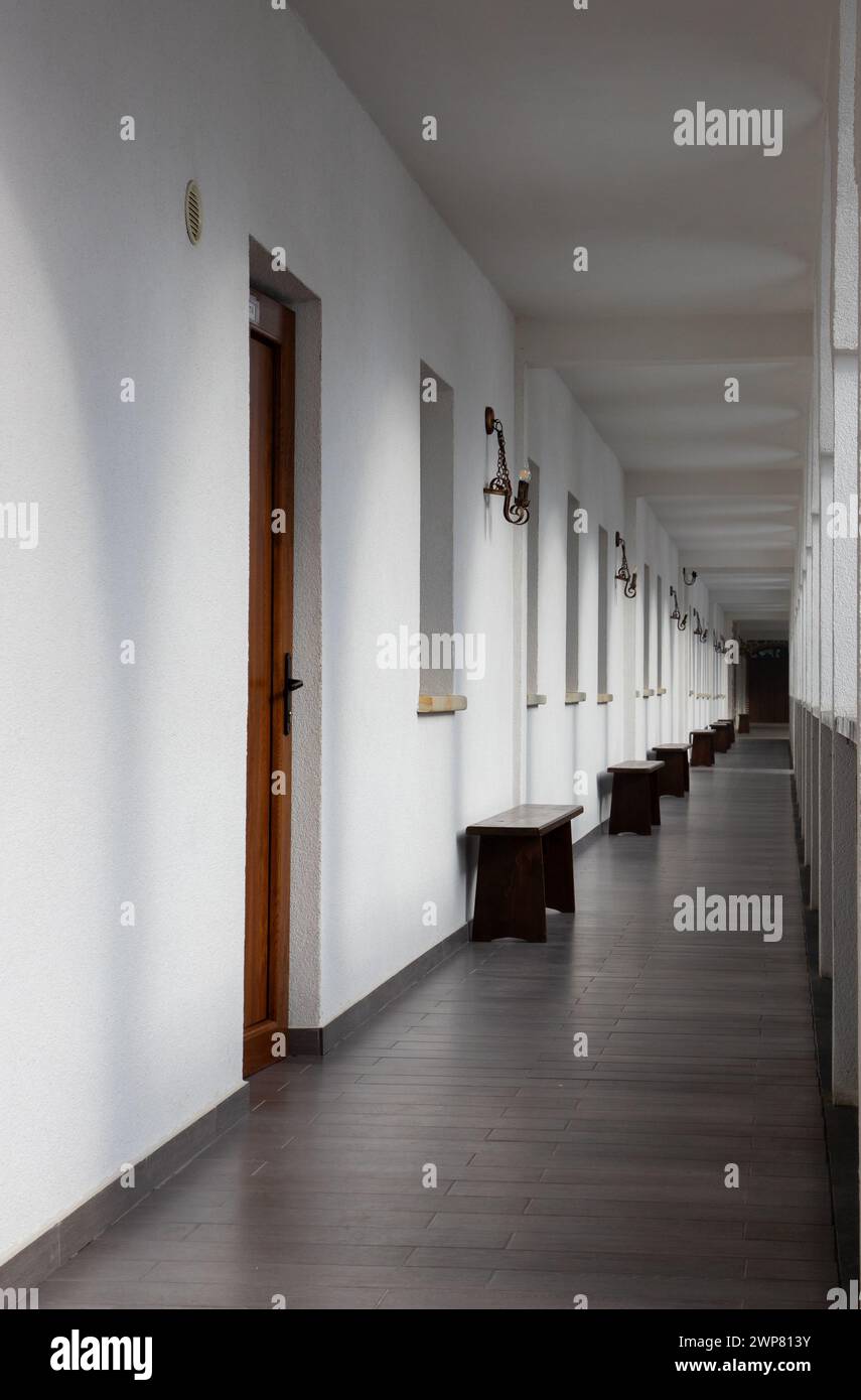 A long, straight corridor with white walls Stock Photo