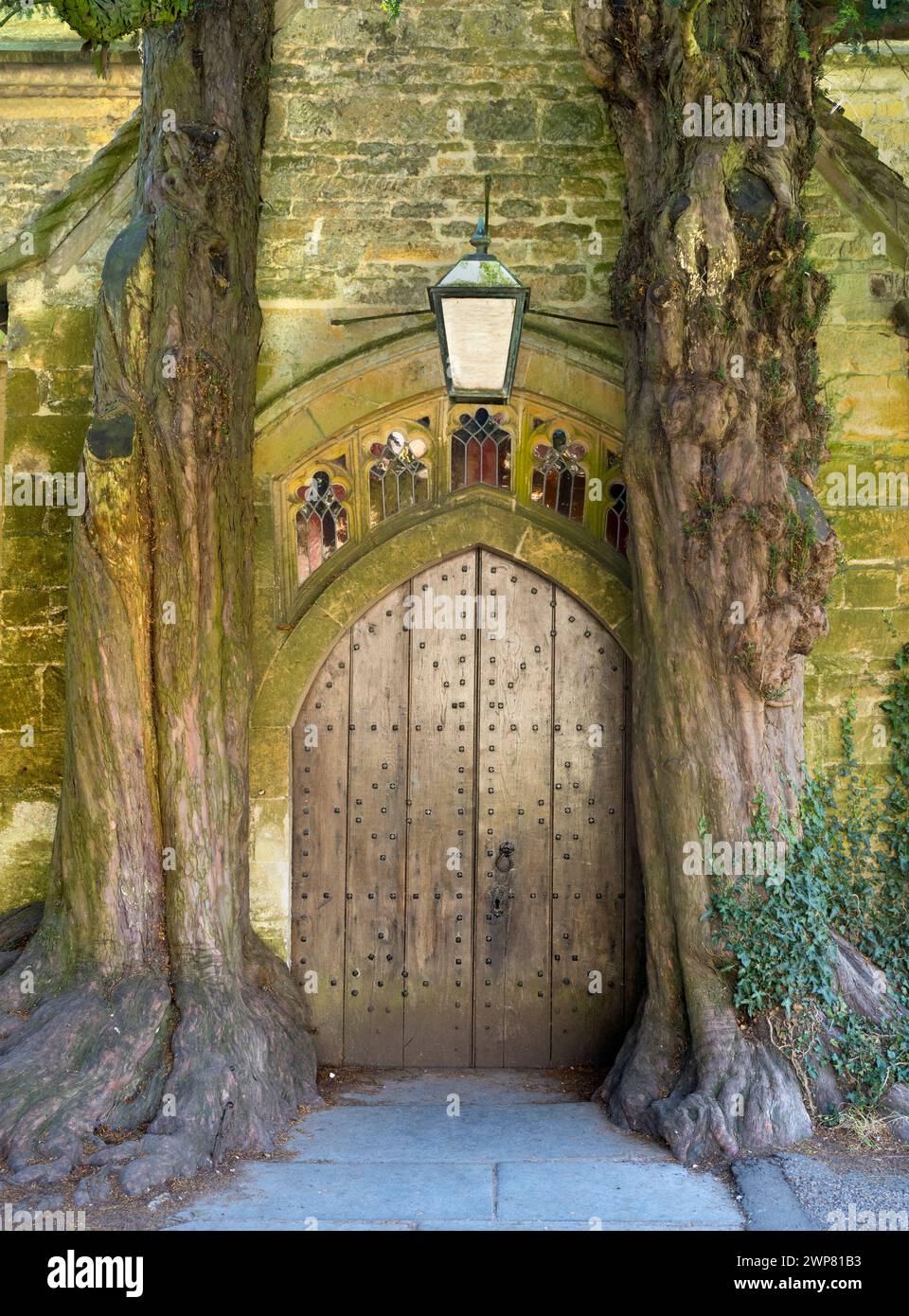 Hidden away in the grounds of the historic St EdwardÕs Church Stow-on-the-Wold in the Cotswolds can be seen this magical medieval church door flanked Stock Photo