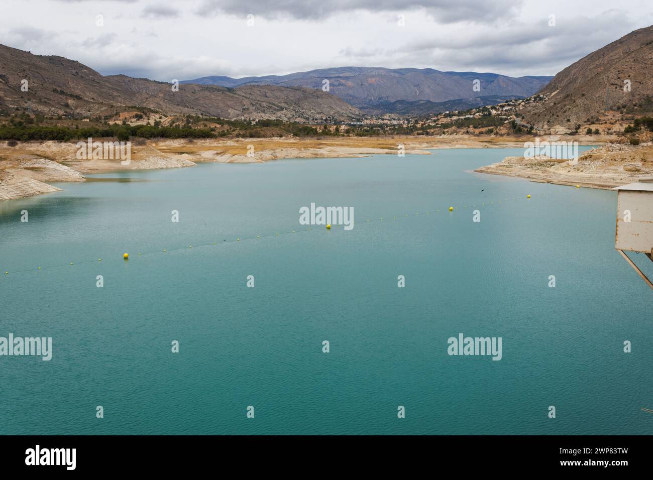 Water shortage in the Amadorio Reservoir due to climate change seen from the railing of the wall. Orxeta, Spain Stock Photo