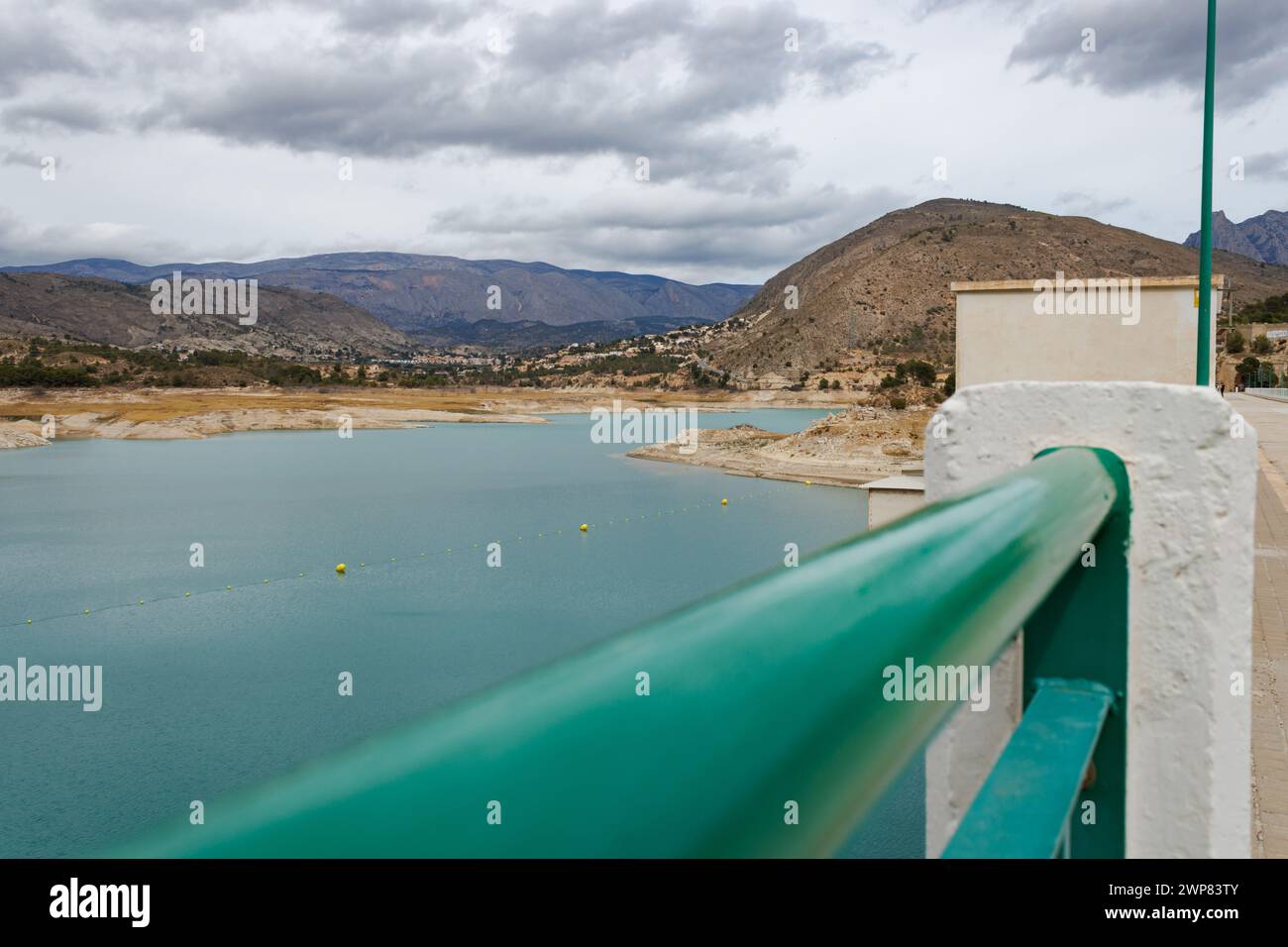 Water shortage in the Amadorio Reservoir due to climate change seen from the railing of the wall. Orxeta, Spain Stock Photo