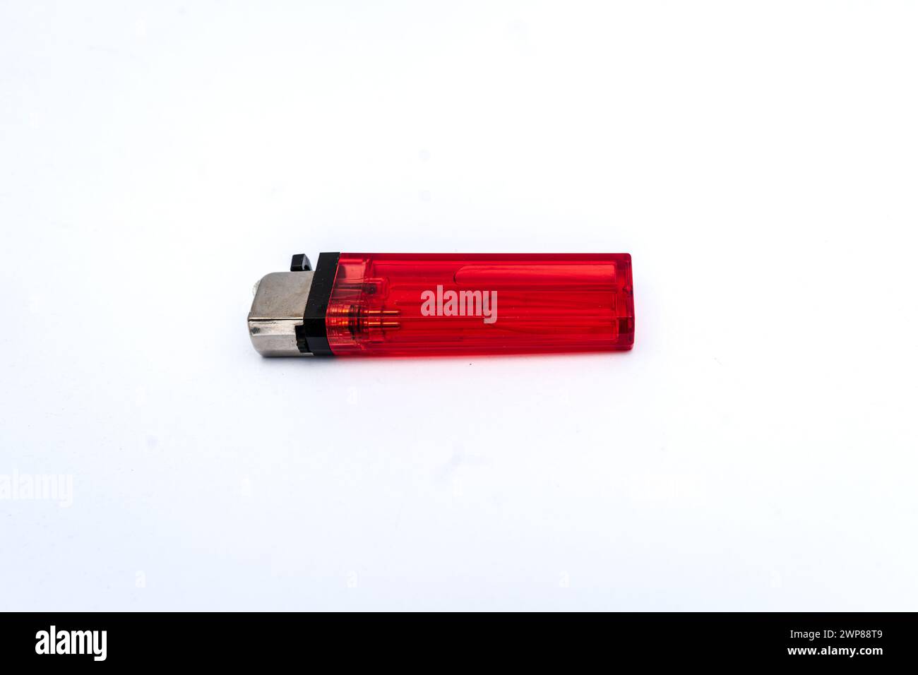 Cheap red cigarette gas lighter made of plastic isolated on white background. Stock Photo