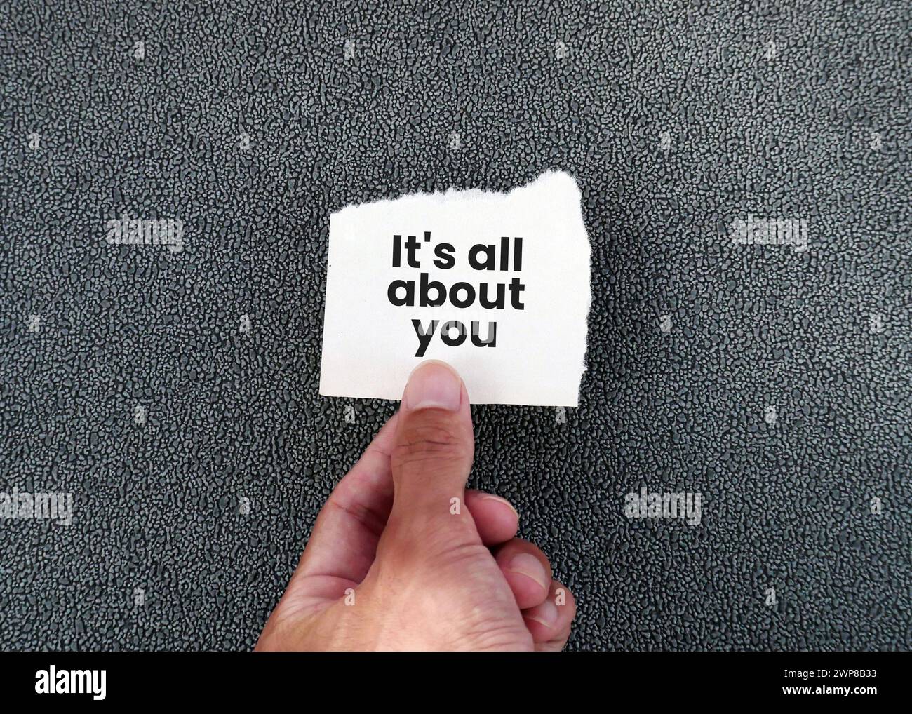 Hand holding torn paper with text It's All About You Stock Photo