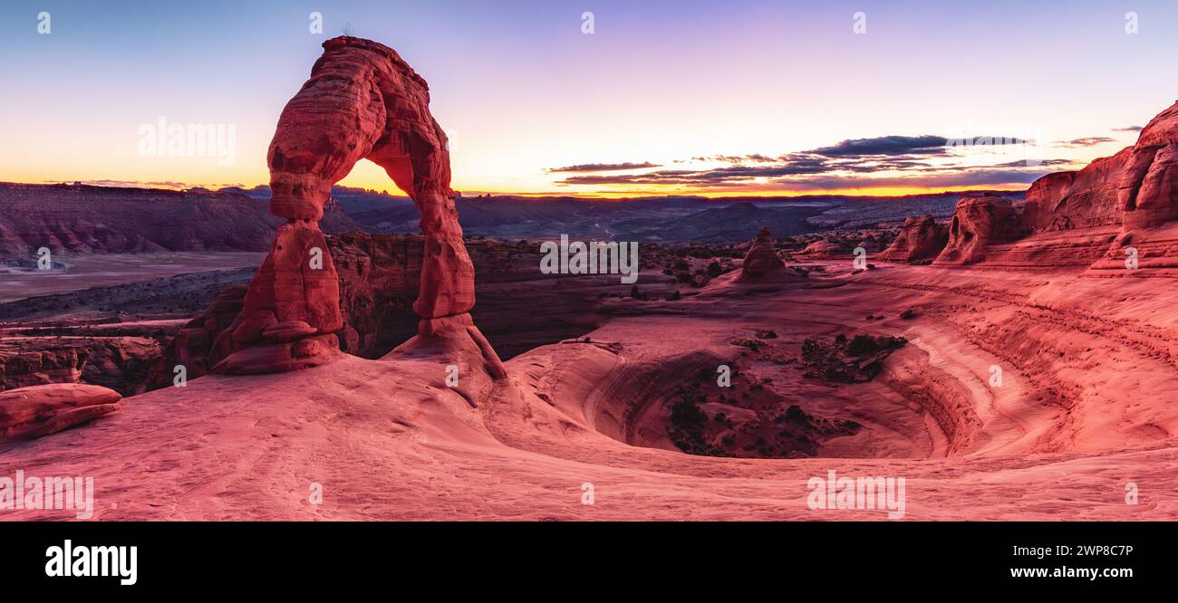 Stone arch in desert landscape with mountains and blue sky Stock Photo ...
