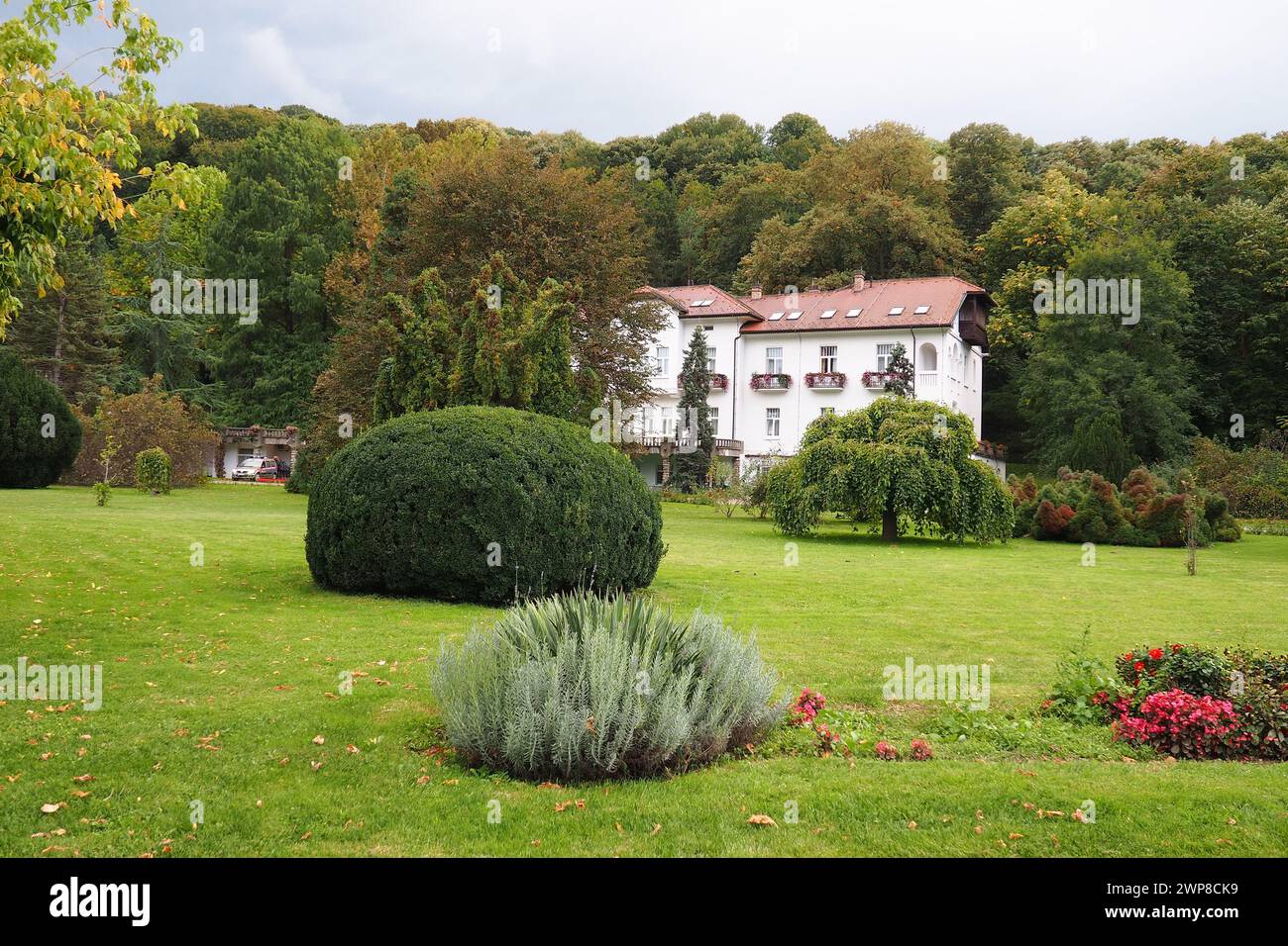 Banja Koviljaca, Serbia, Guchevo, Loznica, September 30, 2022 A medical building, the former royal villa. Green lawn in the park with flowers and bush Stock Photo