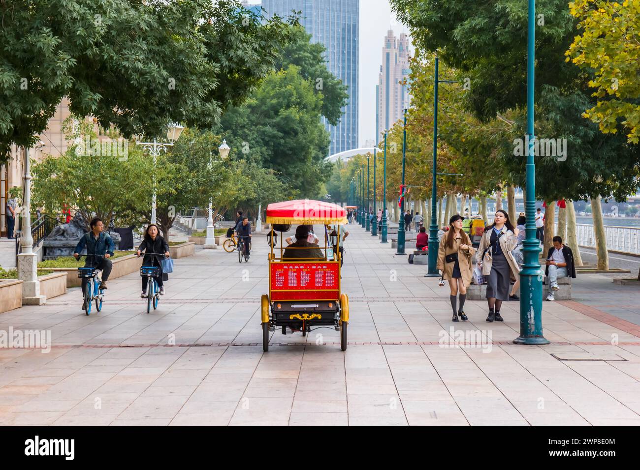 Riksja on the treelined boulevard in Tianjin, China Stock Photo