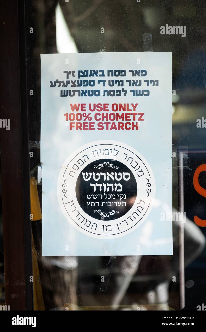 A Yiddish English sign in the window of a Lee Ave laundry in Williamsburg saying that they only use Kosher for Passover starch during the holiday. Stock Photo