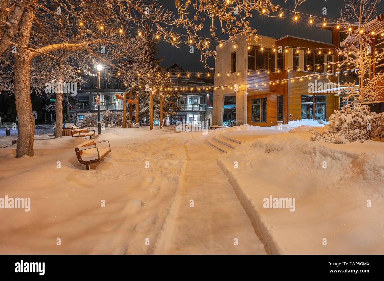 Night view of snow-covered Civic Plaza benches in downtown Canmore, Alberta, Canada Stock Photo