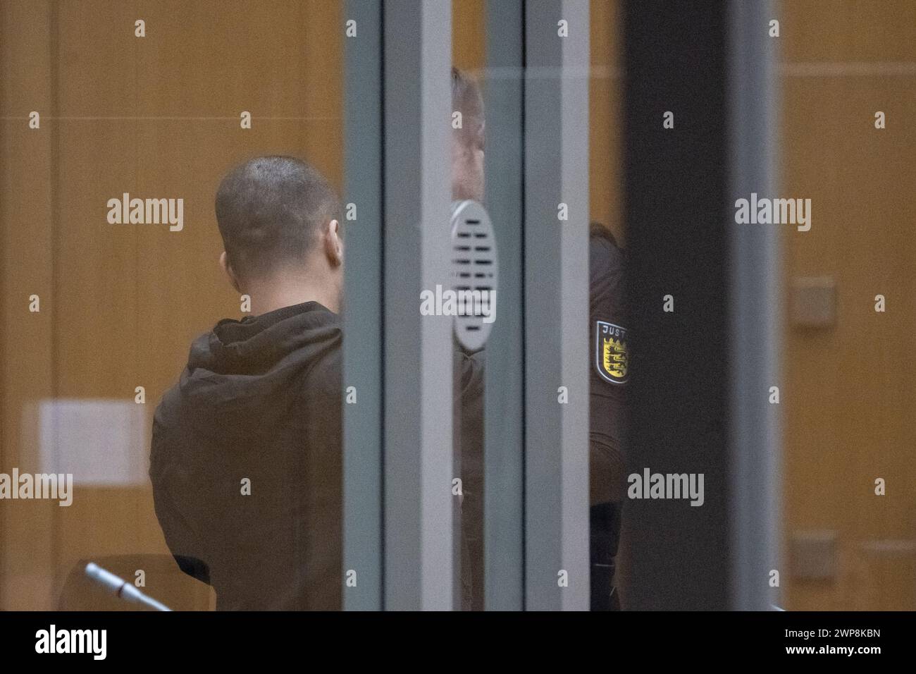 Stuttgart, Germany. 06th Mar, 2024. The defendant (l) in the trial at Stuttgart Regional Court for a hand grenade attack in Altbach stands in a courtroom at the Higher Regional Court in Stammheim. Two rival groups in the Stuttgart area have been waging a bloody feud for many months, culminating in a hand grenade attack on a mourning congregation in Altbach near Esslingen. Credit: -/dpa/Alamy Live News Stock Photo