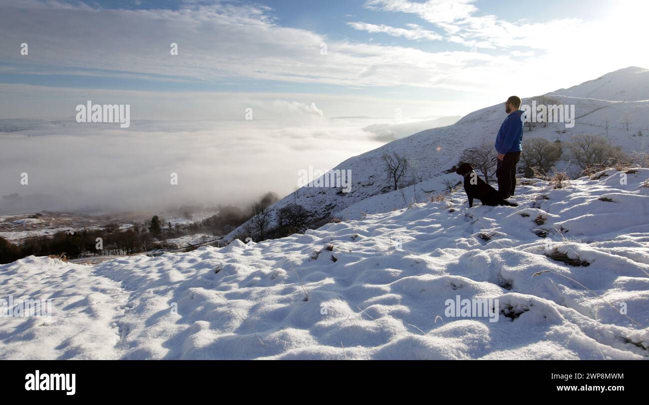 16/01/13  After the coldest night of the winter, Chris Wycech walks his dog Oscar on Mam Tor overlooking a cloud inversion above Castleton, in The Pea Stock Photo
