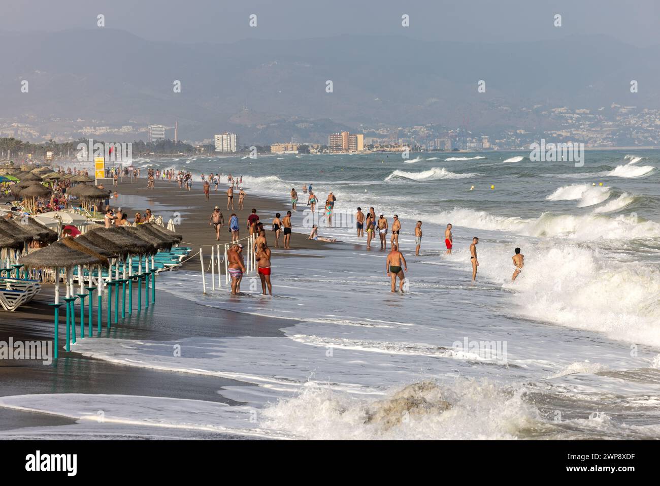 Torremolinos, Spain - September 14, 2023:  Foamy sea waves on the sandy beach of Bajondillo in Torremolinos, Malaga, Costa del Sol, Spain Stock Photo