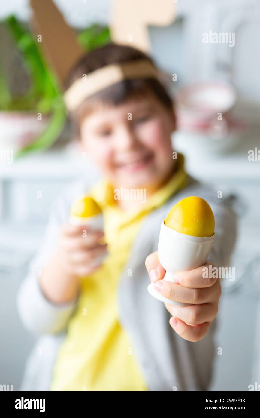 3 March 2024: Little boy playing with yellow colored Easter eggs. Happy child at Easter *** Kleiner Junge spielt mit gelben gefärbten Ostereiern. Glückliches Kind an Ostern Stock Photo