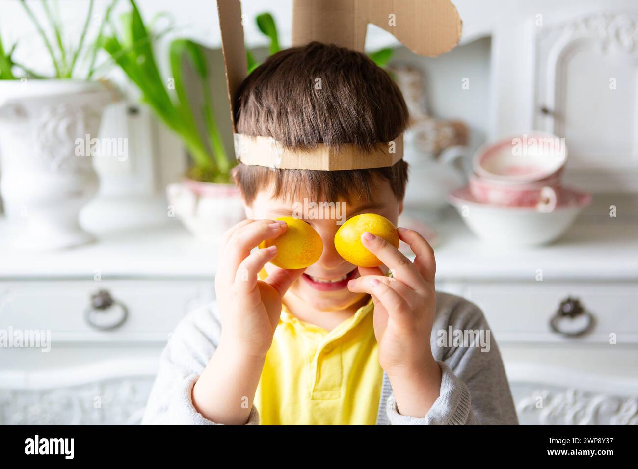 3 March 2024: Little boy playing with yellow colored Easter eggs. Happy child at Easter *** Kleiner Junge spielt mit gelben gefärbten Ostereiern. Glückliches Kind an Ostern Stock Photo