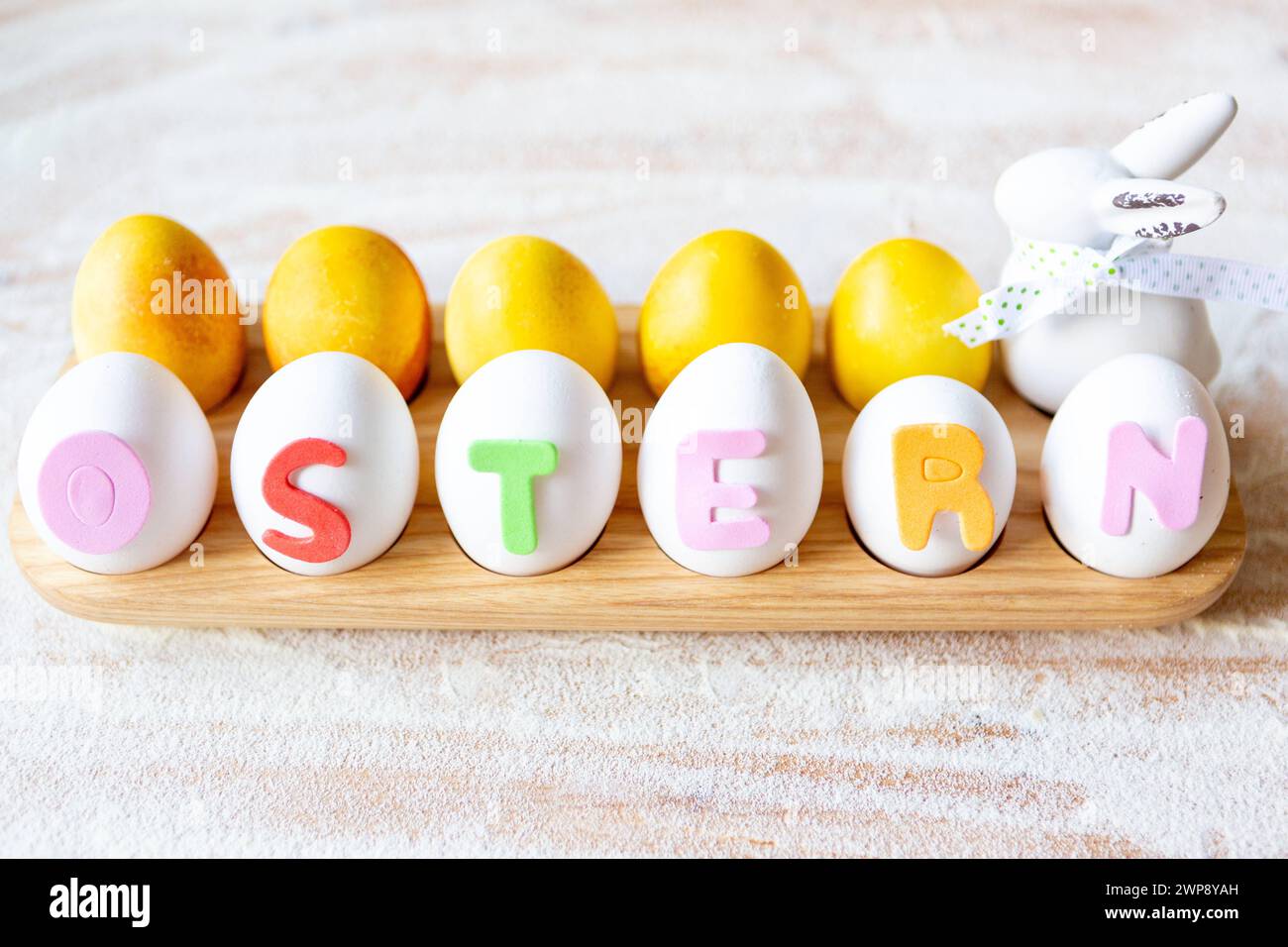 3 March 2024: Colored and white eggs for Easter with a ceramic Easter bunny and the lettering: Easter. Colorful letters on eggs *** Gefärbte und Weiße Eier zu Ostern mit einem Keramik Osterhasen und dem Schriftzug: Ostern. Bunte Buchstaben auf Eiern Stock Photo
