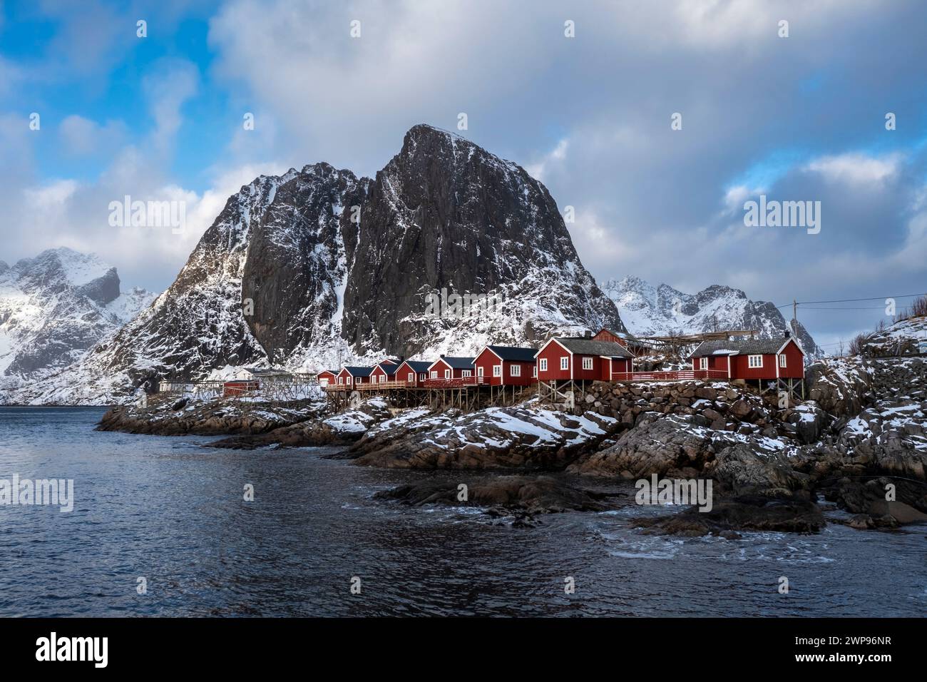 View of the Hamnøya island with the famous red rorbuer and the Lilandstinden mountain in Reine Bay during winter. Lofoten Islands, Norway. Stock Photo
