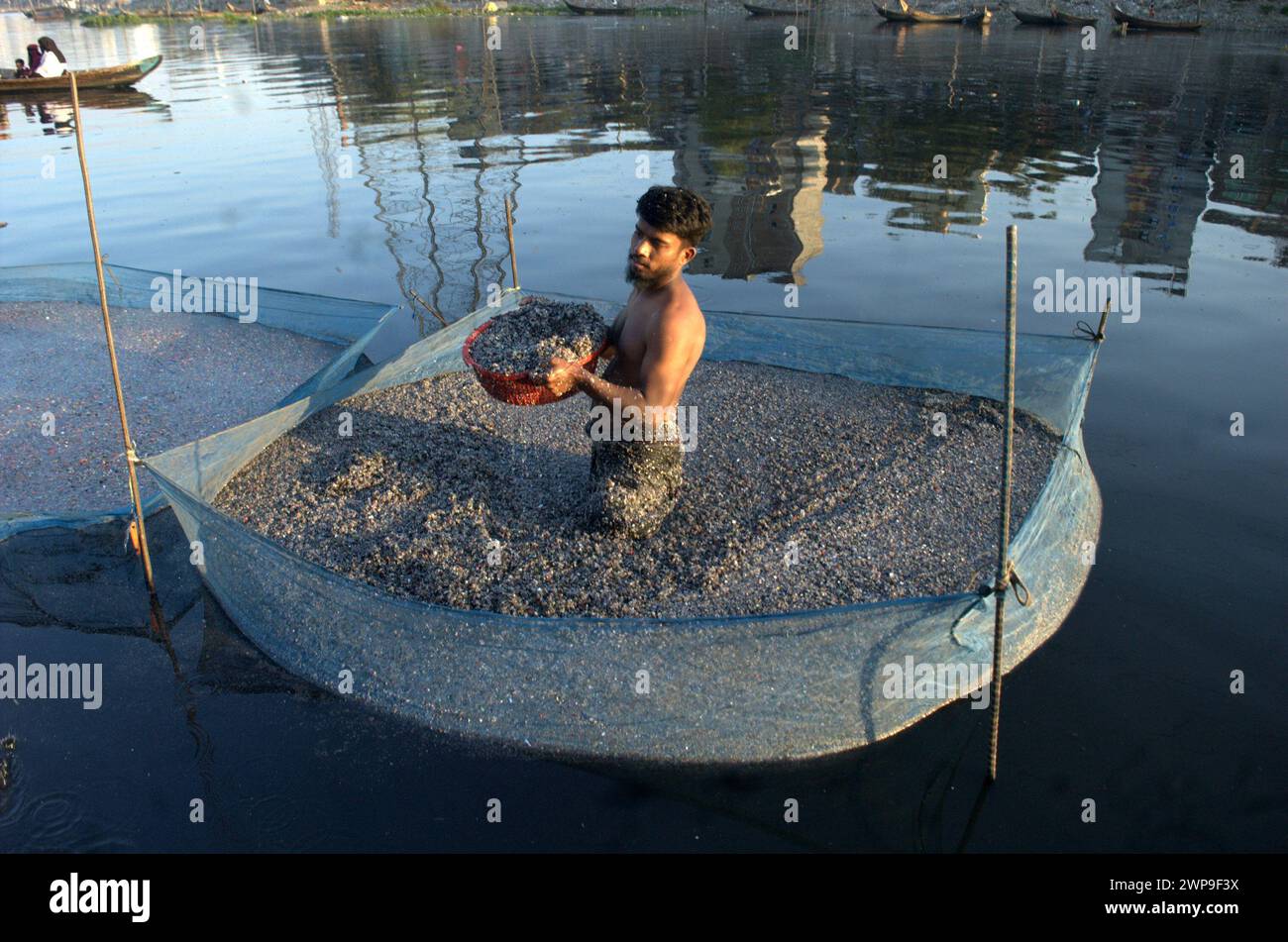 Dhaka, Bangladesh. 6th Mar, 2024. A worker cleans plastic granules in the water of the canal of the Buriganga River in Dhaka. (Credit Image: © MD Mehedi Hasan/ZUMA Press Wire) EDITORIAL USAGE ONLY! Not for Commercial USAGE! Stock Photo