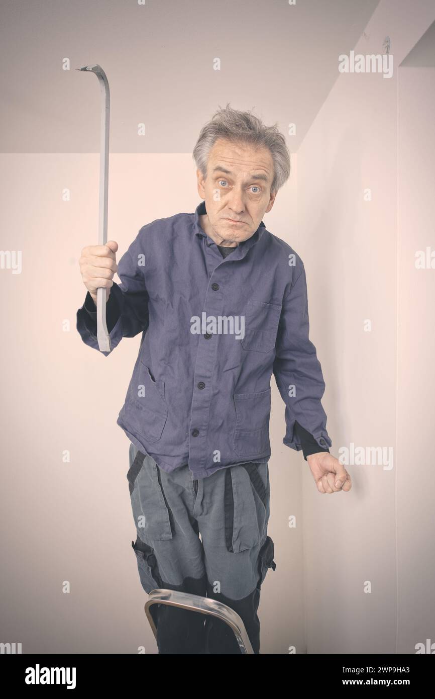 Older man repairing walls and ceiling in empty apartment Stock Photo