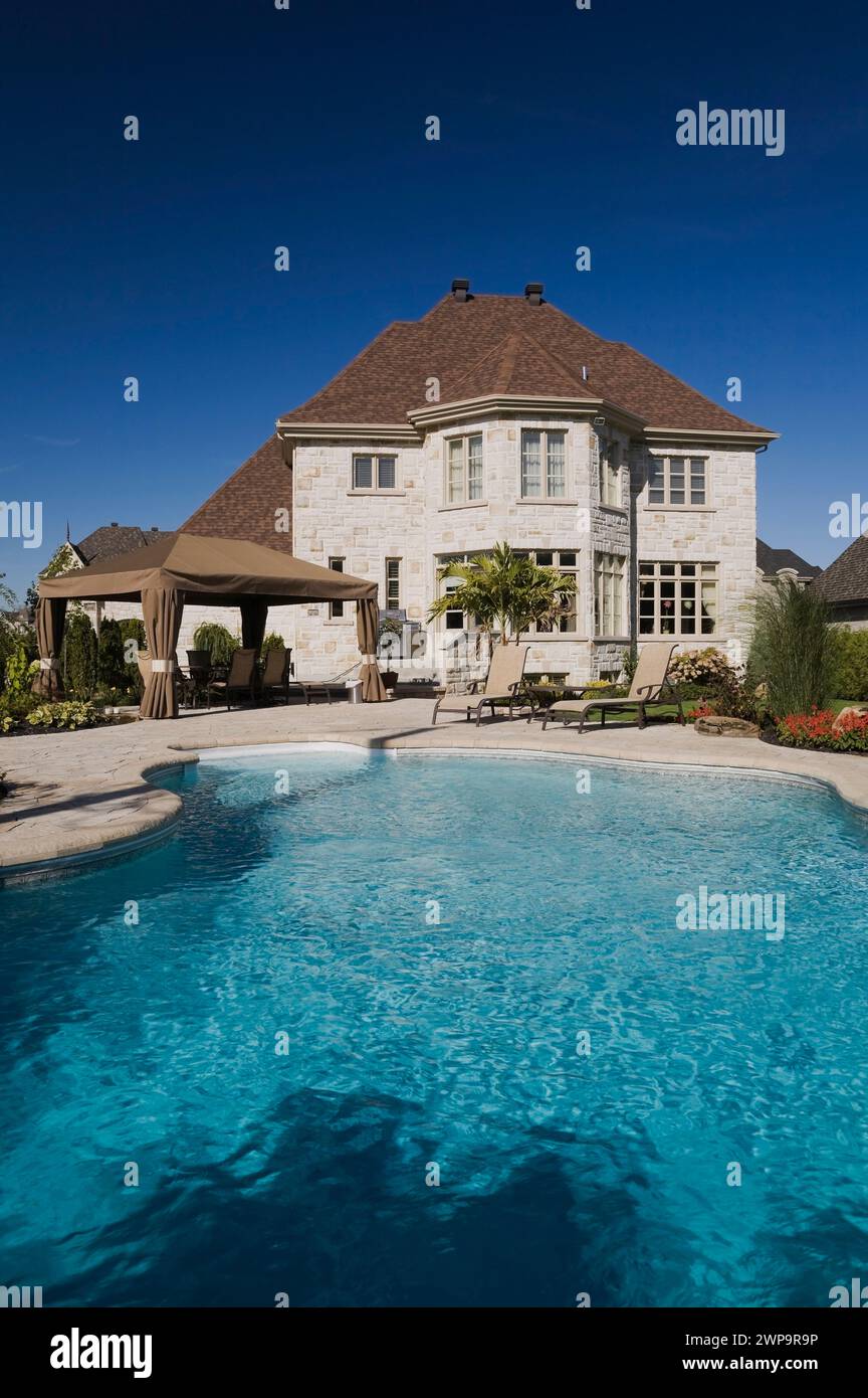 In-ground swimming pool in backyard of luxurious two story tan and ...