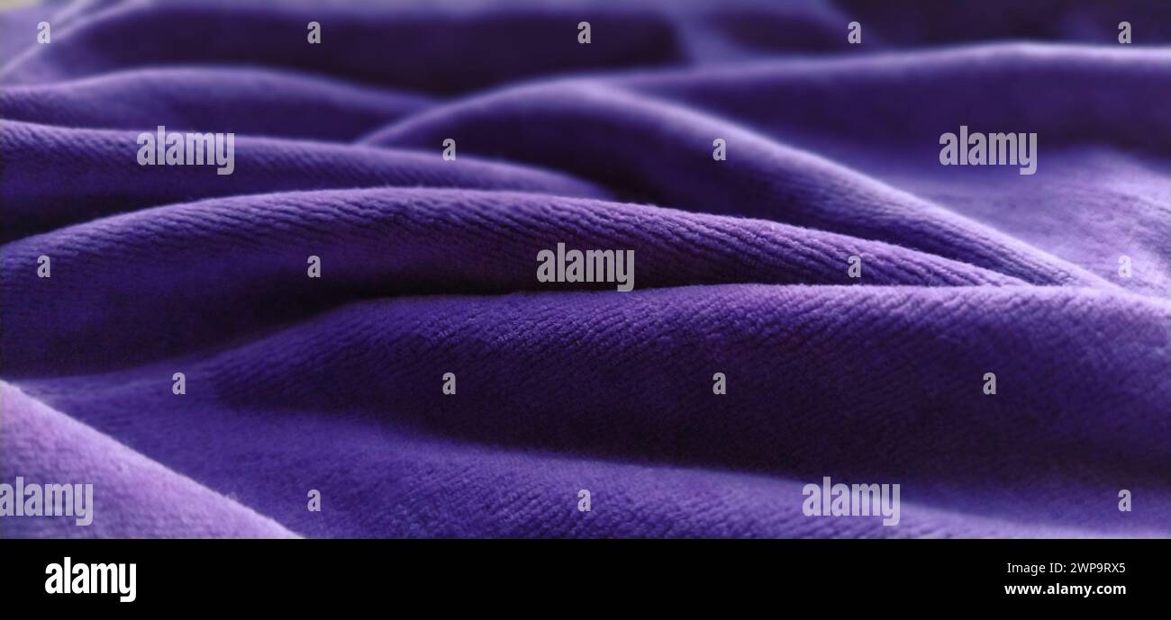 Blue wrinkled velvet. Blue-violet velvet fabric, beautifully laid in waves. Soft focus. Stock Photo