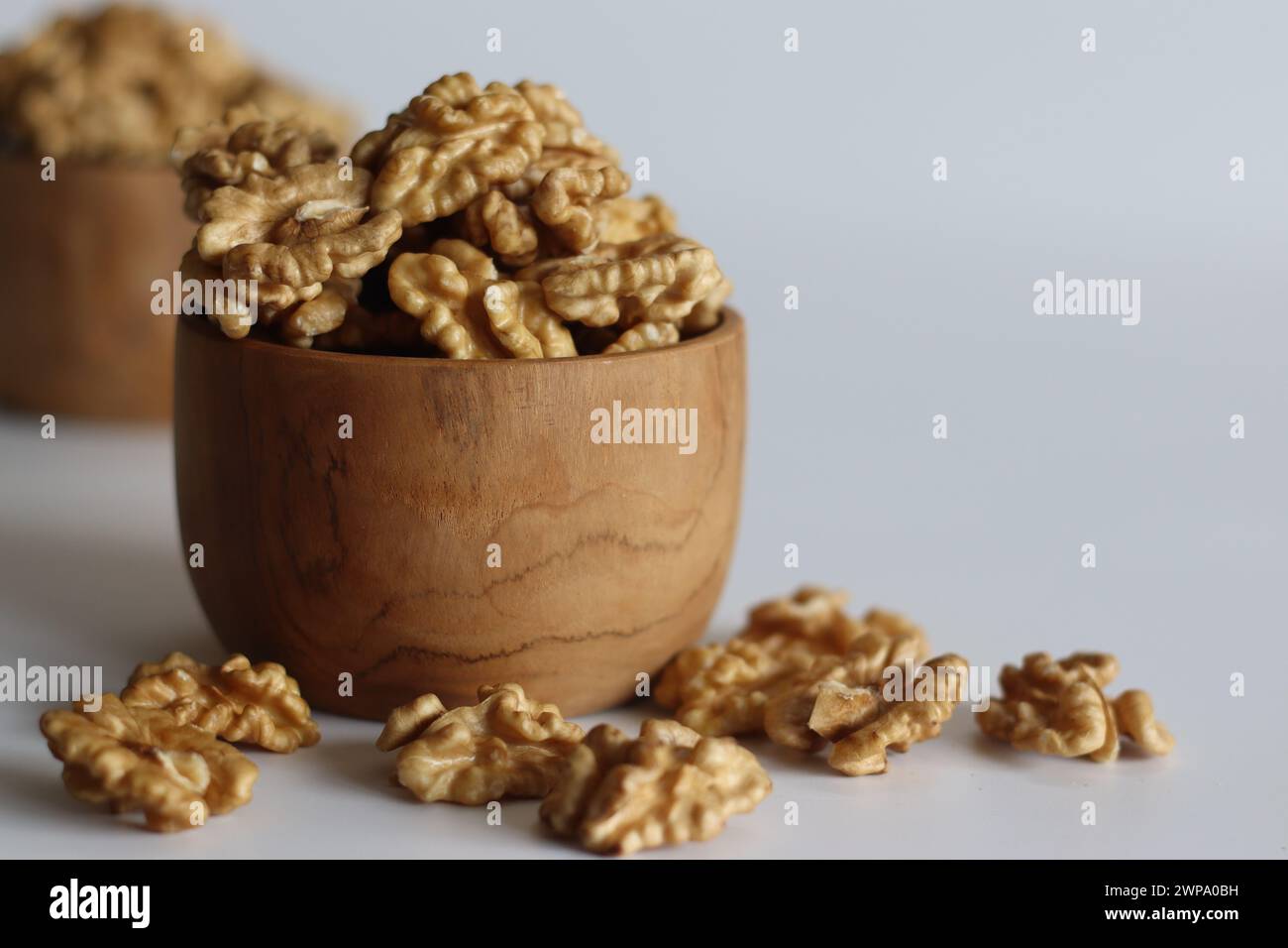 Pristine pile of premium dry walnuts in a wooden bowl, ideal for culinary creations and healthy snacks. Nut lovers rejoice in this bountiful harvest. Stock Photo