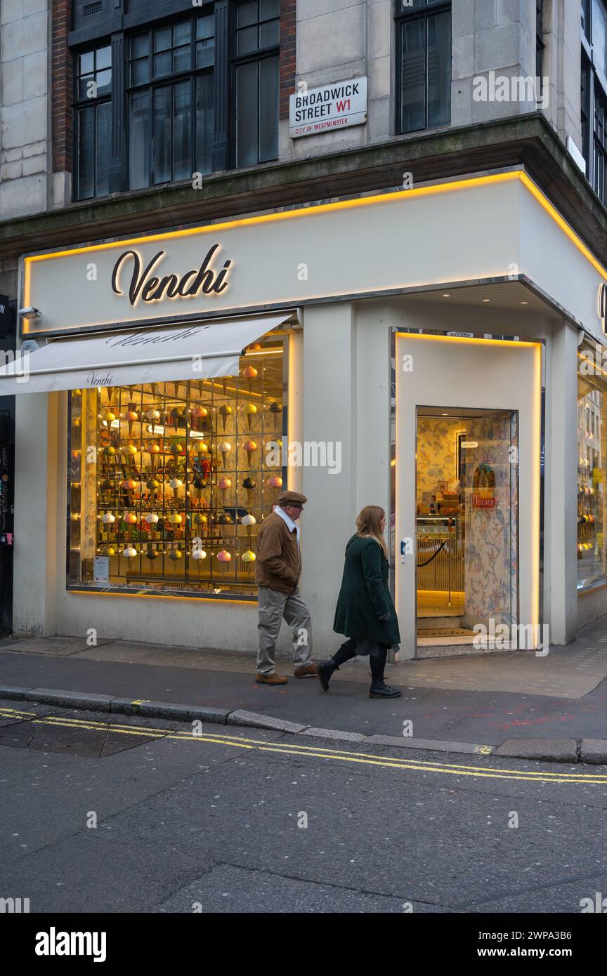 Man and woman walk by Venchi Chocolate & Gelato shop on corner of ...