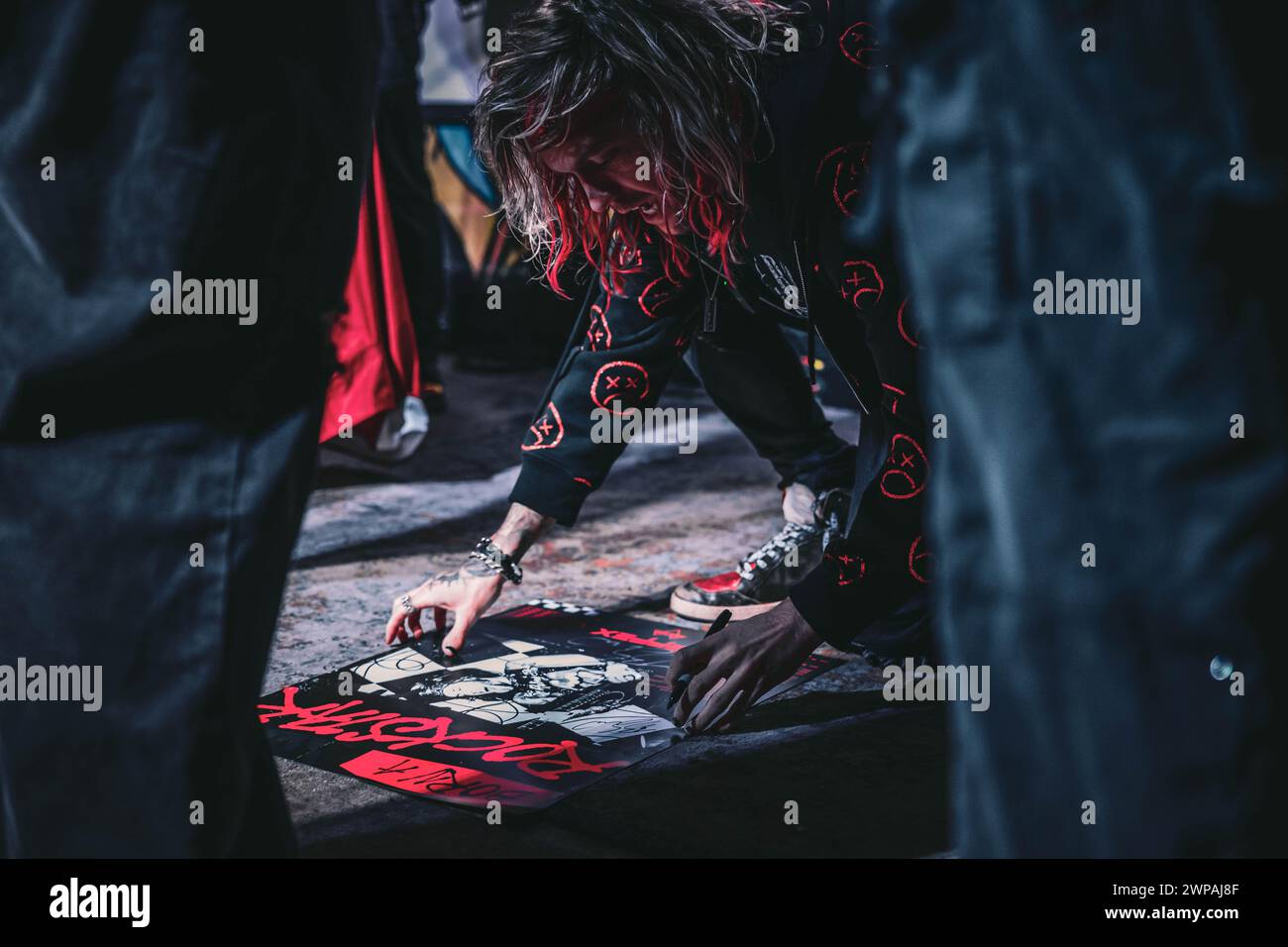 An artist paints in front of an audience Stock Photo