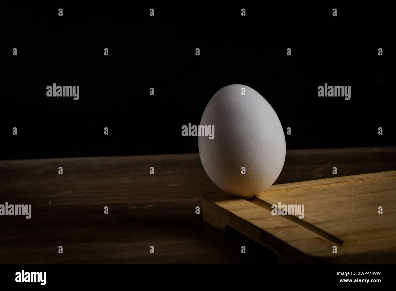 Egg on the edge,black background Stock Photo
