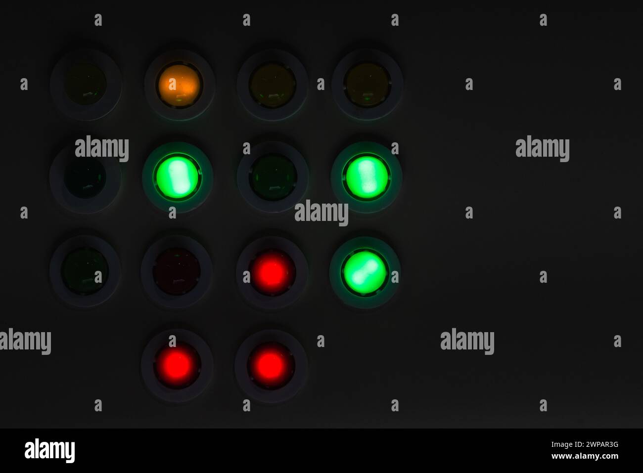 Dark industrial control panel with colorful illuminated buttons at night Stock Photo