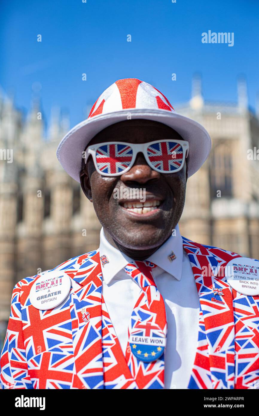 Pro-Brexit demonstrator wears a suit with a pattern of British Union flags, also known as Union Jacks, near the Houses of Parliament in London, U.K Stock Photo
