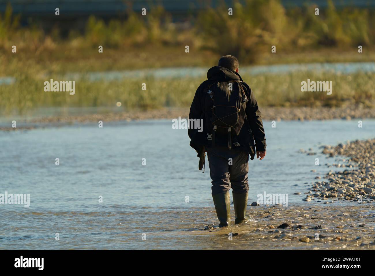 Man walking in a stream. looking for precious stones in water. Stock Photo