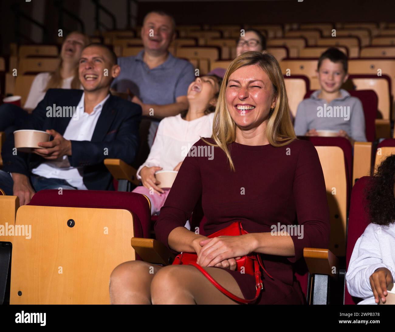 caucasian woman sitting at funny perfomance in theatrical auditorium Stock Photo