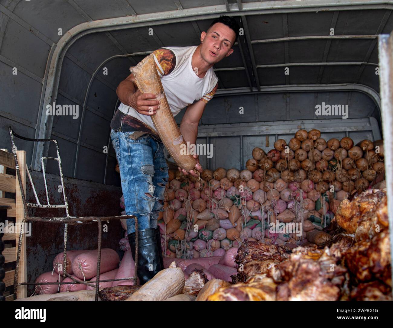 Young man sweating and perspiring on a hot day, works tossing and delivering food at a cafe in Havana, Cuba Stock Photo