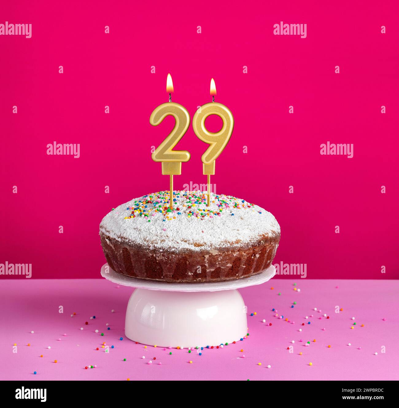Birthday cake with number 29 candle on pink background Stock Photo