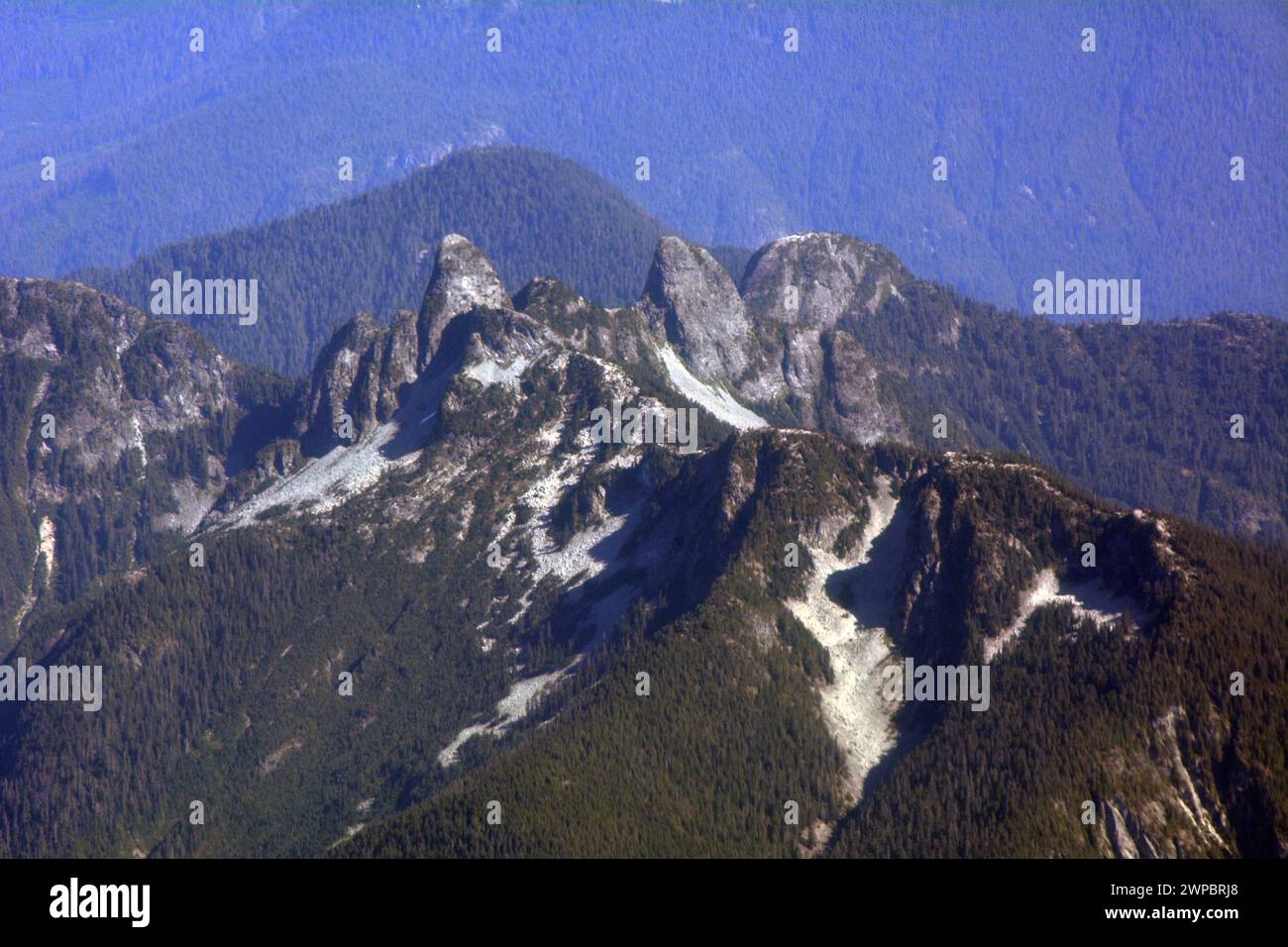 An aerial summer view of 'The Lions', a pair of peaks in the North Shore Mountains above Vancouver, Pacific Coast Mountains, British Columbia, Canada. Stock Photo