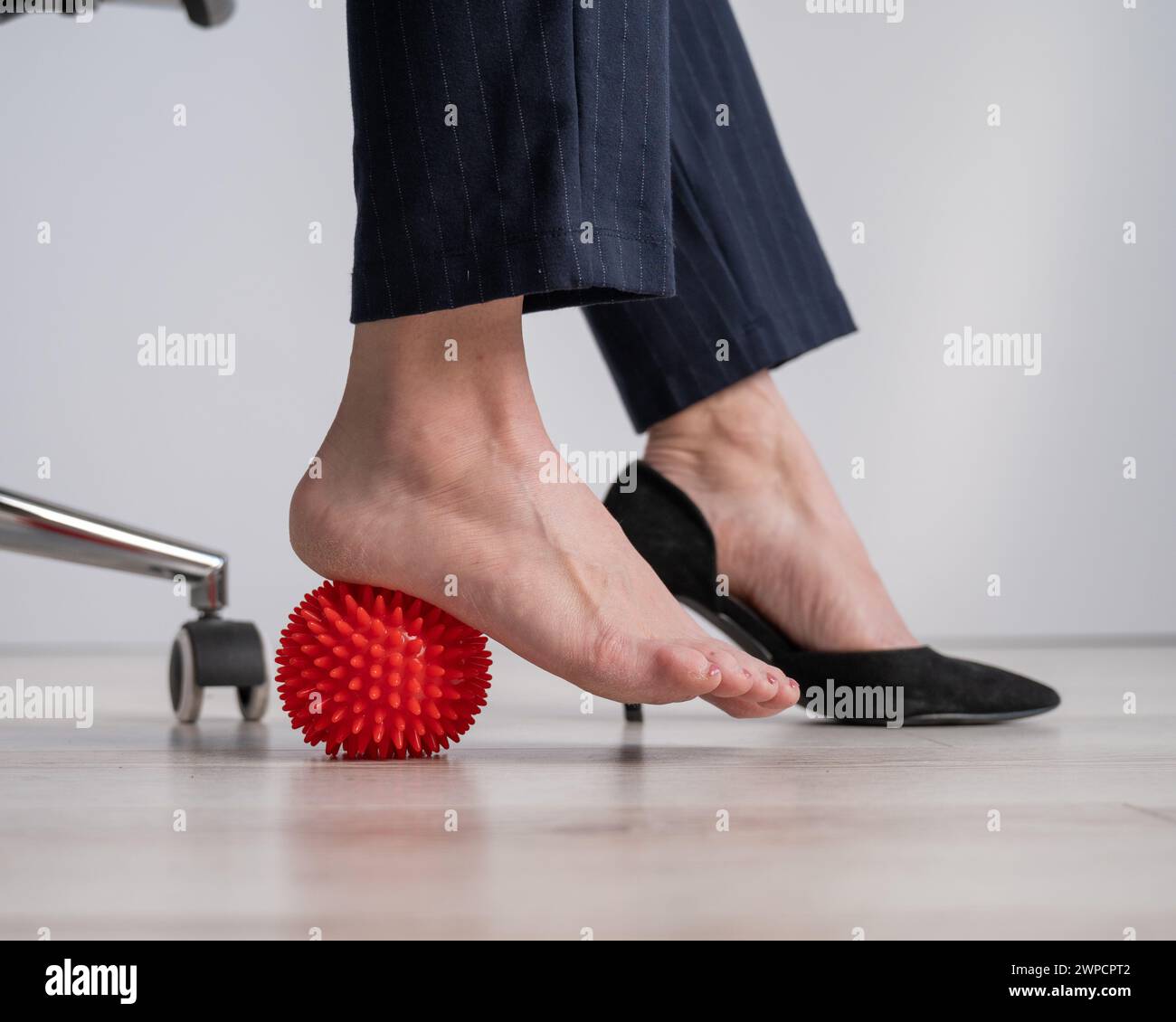 Business woman massages her feet on a massage ball with spikes Stock ...